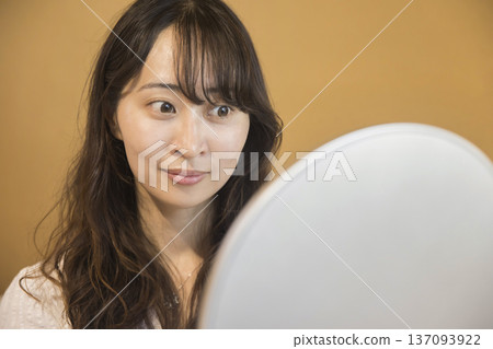 Young woman looking in the mirror after beauty treatment Young woman looking in the mirror after beauty treatment 137093922