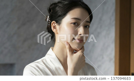身穿白色長袍的日本女子，手托下巴，面帶溫柔的微笑。 137094683