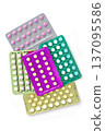 Collection of hormonal birth control pills in different colors and packaging. 137095586