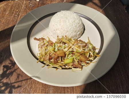 A delicious Asian food dish served on a plate, including rice and a vegetable stir fry A delicious Asian food dish served on a plate, including rice and a vegetable stir fry 137096030