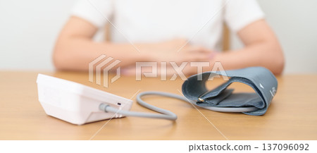 woman checking Blood pressure by Blood pressure monitor with Cuff. Systolic, SYS, Diastolic, DIA, Pulse, Hypertension, Hypotension, Heart rate, Cardiovascular Disease and May World hypertension day 137096092