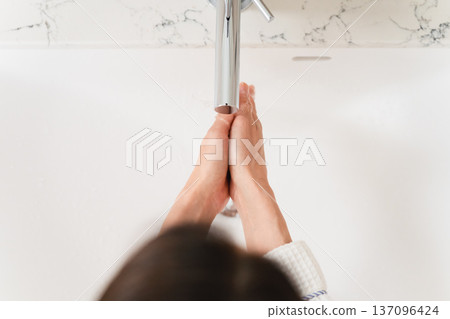 Woman washing her hands in the bathroom Lifestyle image Woman washing her hands in the bathroom Lifestyle image 137096424