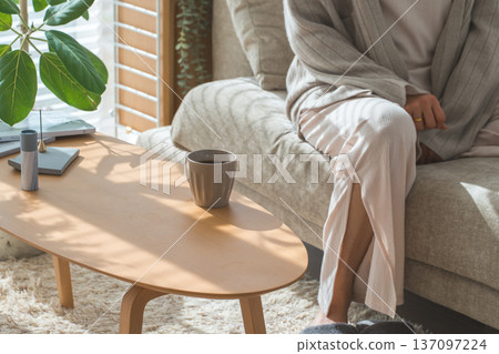 Stylish Asian woman drinking morning coffee in the living room Stylish Asian woman drinking morning coffee in the living room 137097224