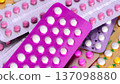 Collection of hormonal birth control pills in different colors and packaging. 137098880