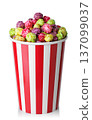 Caramelized fruit popcorn in red and white striped paper bucket isolated on white 137099037