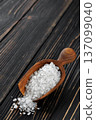 sea salt in wooden scoop on dark wooden table 137099040