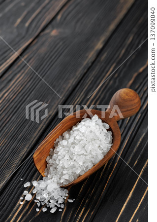 sea salt in wooden scoop on dark wooden table sea salt in wooden scoop on dark wooden table 137099040