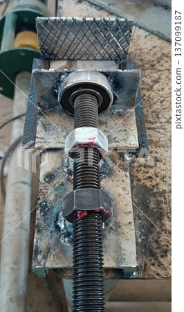 Homemade Mechanical Press Component with Threaded Rod and Bearing in a Workshop Homemade Mechanical Press Component with Threaded Rod and Bearing in a Workshop 137099187