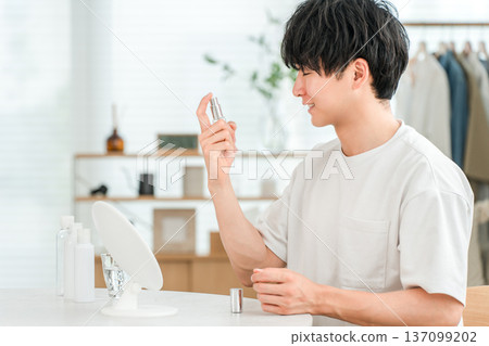A young Asian man spraying his face with skin care (men's beauty, moisturizing, lotion) A young Asian man spraying his face with skin care (men's beauty, moisturizing, lotion) 137099202