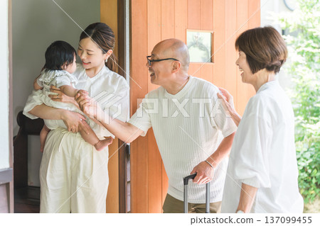 女兒和外孫在前門迎接從鄉下探望的父母。 女兒和外孫在前門迎接從鄉下探望的父母。 137099455