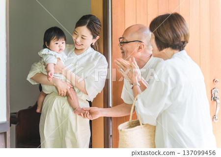 女兒和外孫在前門迎接從鄉下探望的父母。 女兒和外孫在前門迎接從鄉下探望的父母。 137099456
