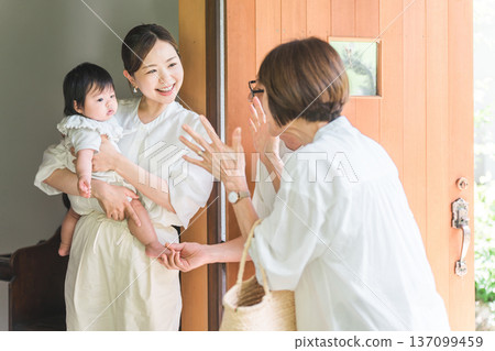 女兒和外孫在前門迎接從鄉下探望的父母。 137099459