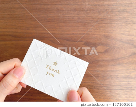 Woman's hand holding a thank you message card Woman's hand holding a thank you message card 137100161