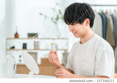 Young Asian man holding a bottle of oral medication, medicine supplements Young Asian man holding a bottle of oral medication, medicine supplements 137100211