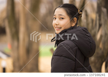Girl looking back in the park Girl looking back in the park 137100241