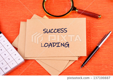 Success Loading cards on orange, with calculator, pen, and magnifier for planning growth Success Loading cards on orange, with calculator, pen, and magnifier for planning growth 137100887