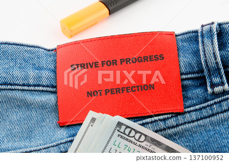 Blue denim, red patch STRIVE FOR PROGRESS, 100 bills, highlighter on white. Symbolizes ambition Blue denim, red patch STRIVE FOR PROGRESS, 100 bills, highlighter on white. Symbolizes ambition 137100952