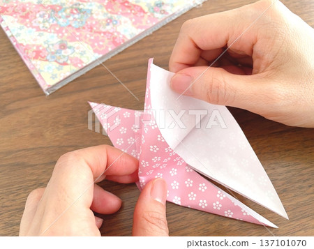 Japanese woman folding origami at a table Japanese woman folding origami at a table 137101070