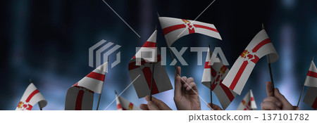 Northern Ireland flags in their hands on a blurred urban background 137101782