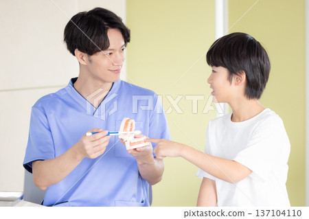 Dentist: Boy and doctor receiving tooth brushing instruction 137104110