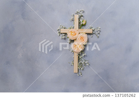Wooden christian cross with pink roses and gypsophila flowers on a dark shadow wall representing faith and easter symbolizing copyspace faith, resurrection 137105262