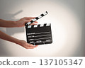 Hands holding clapperboard, signaling action on film set a scene directing production, movie 137105347