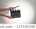 Hands holding clapperboard, signaling action on film set a movie production, scene directing 137105348