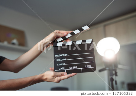 Person holding film clapperboard cueing start of production, motion video picture, content or creation Person holding film clapperboard cueing start of production, motion video picture, content or creation 137105352