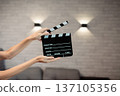 Hands holding clapperboard, signaling start of film production, cinematic movie making storytelling, industry concept 137105356