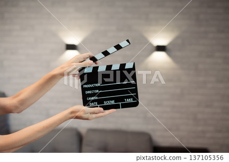 Hands holding clapperboard, signaling start of film production, cinematic movie making storytelling, industry concept Hands holding clapperboard, signaling start of film production, cinematic movie making storytelling, industry concept 137105356