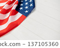 American flag fabric USA showing stars and stripes on a white wooden background, representing national identity, democracy, and copy space celebration 137105360