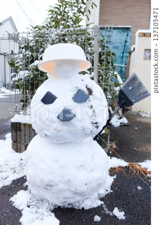 A snowman made by a child on a snowy day A snowman made by a child on a snowy day 137105471