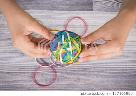 Preschooler hands with ball of rubber bands or erasers Preschooler hands with ball of rubber bands or erasers 137105993