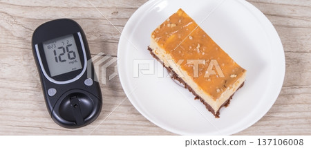Glucose meter with high result sugar level and portion of sweet cheesecake 137106008