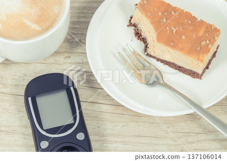 Glucose meter, piece of sweet cheesecake and cup of coffee with milk Glucose meter, piece of sweet cheesecake and cup of coffee with milk 137106014