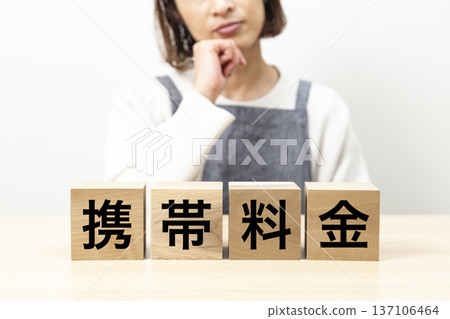 A woman in an apron is worried about a block that reads "Mobile phone charges" A woman in an apron is worried about a block that reads "Mobile phone charges" 137106464