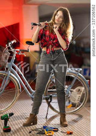 Young woman playfully posing with bicycle handlebars Young woman playfully posing with bicycle handlebars 137106562