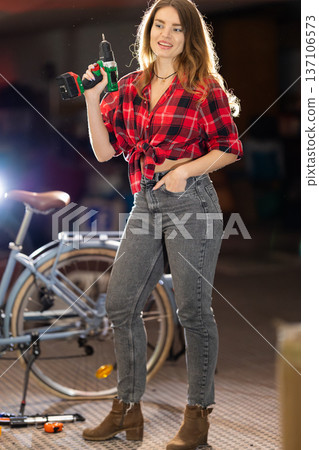 Young woman holding drill working in workshop Young woman holding drill working in workshop 137106573