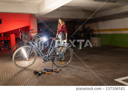 Woman repairing bicycle in garage workshop 137106581