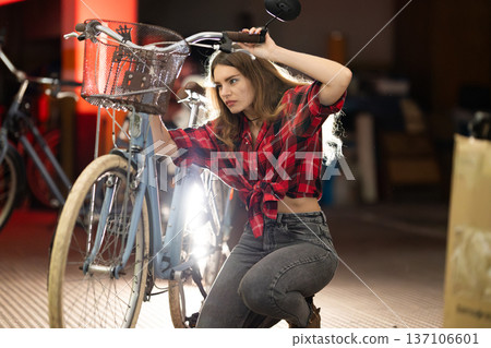 Young woman repairing bicycle, focusing on maintenance and fixing Young woman repairing bicycle, focusing on maintenance and fixing 137106601