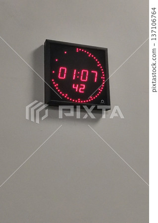 Digital led wall clock with red segmented display showing time and seconds for public space timing and interior signage use 137106764