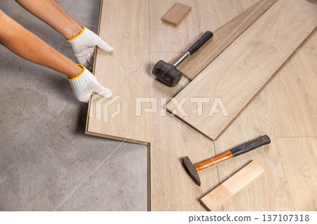 Worker Installing Interlocking laminate floor, home renovation. 137107318