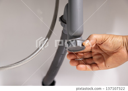 Plumber open trap to fixing drain clog under sink. 137107322