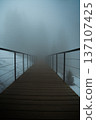 Wooden bridge pathway vanishing into thick fog 137107425