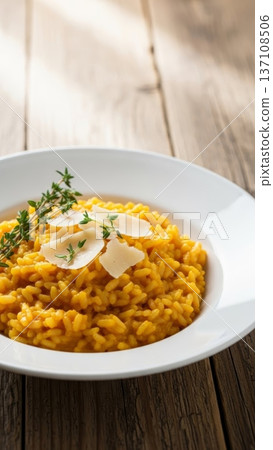 Classic saffron risotto with parmesan shavings in a white bowl for recipe, menu, and food blog background Classic saffron risotto with parmesan shavings in a white bowl for recipe, menu, and food blog background 137108506