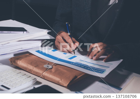 Professional photo of a person's hands reviewing a contract or legal document on a desk, for concepts of business, finance, and legal affairs Professional photo of a person's hands reviewing a contract or legal document on a desk, for concepts of business, finance, and legal affairs 137108706