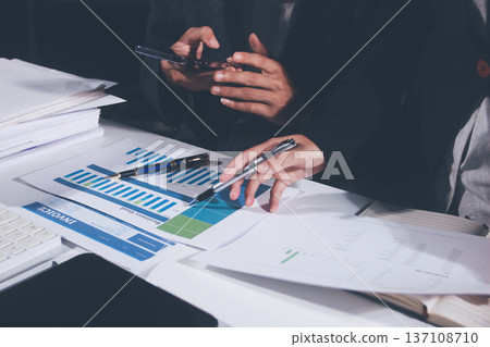 Professional photo of a person's hands reviewing a contract or legal document on a desk, for concepts of business, finance, and legal affairs Professional photo of a person's hands reviewing a contract or legal document on a desk, for concepts of business, finance, and legal affairs 137108710