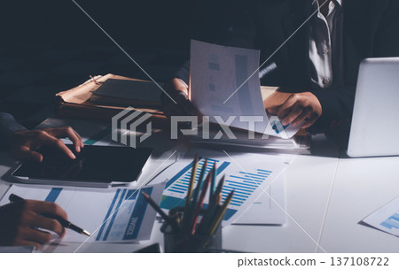 Professional photo of a person's hands reviewing a contract or legal document on a desk, for concepts of business, finance, and legal affairs 137108722