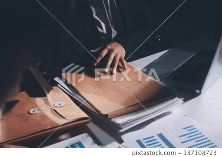 Professional photo of a person's hands reviewing a contract or legal document on a desk, for concepts of business, finance, and legal affairs Professional photo of a person's hands reviewing a contract or legal document on a desk, for concepts of business, finance, and legal affairs 137108723