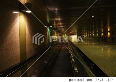 Modern Airport Travelator with Warm Ambient Lighting and Green Accents 137109182